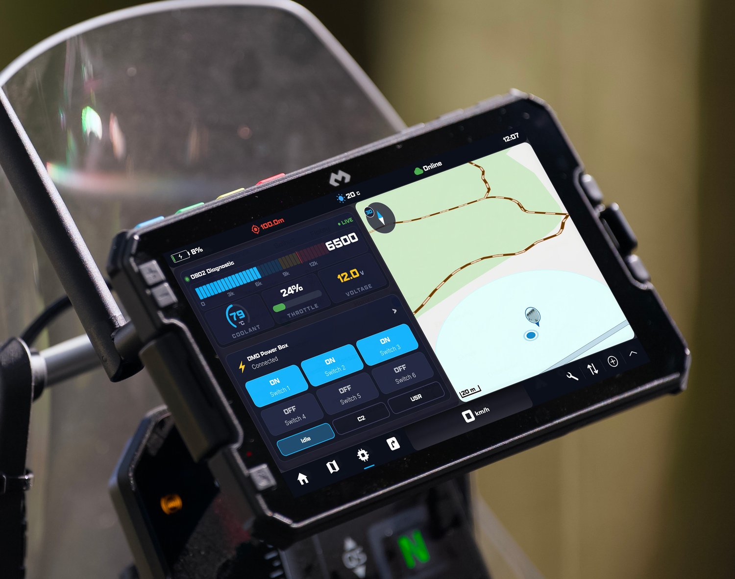 A DMD tablet on a motorcycle showing live ECU data — RPM, coolant, throttle and voltage — beside the DMD Power Box switches and the map